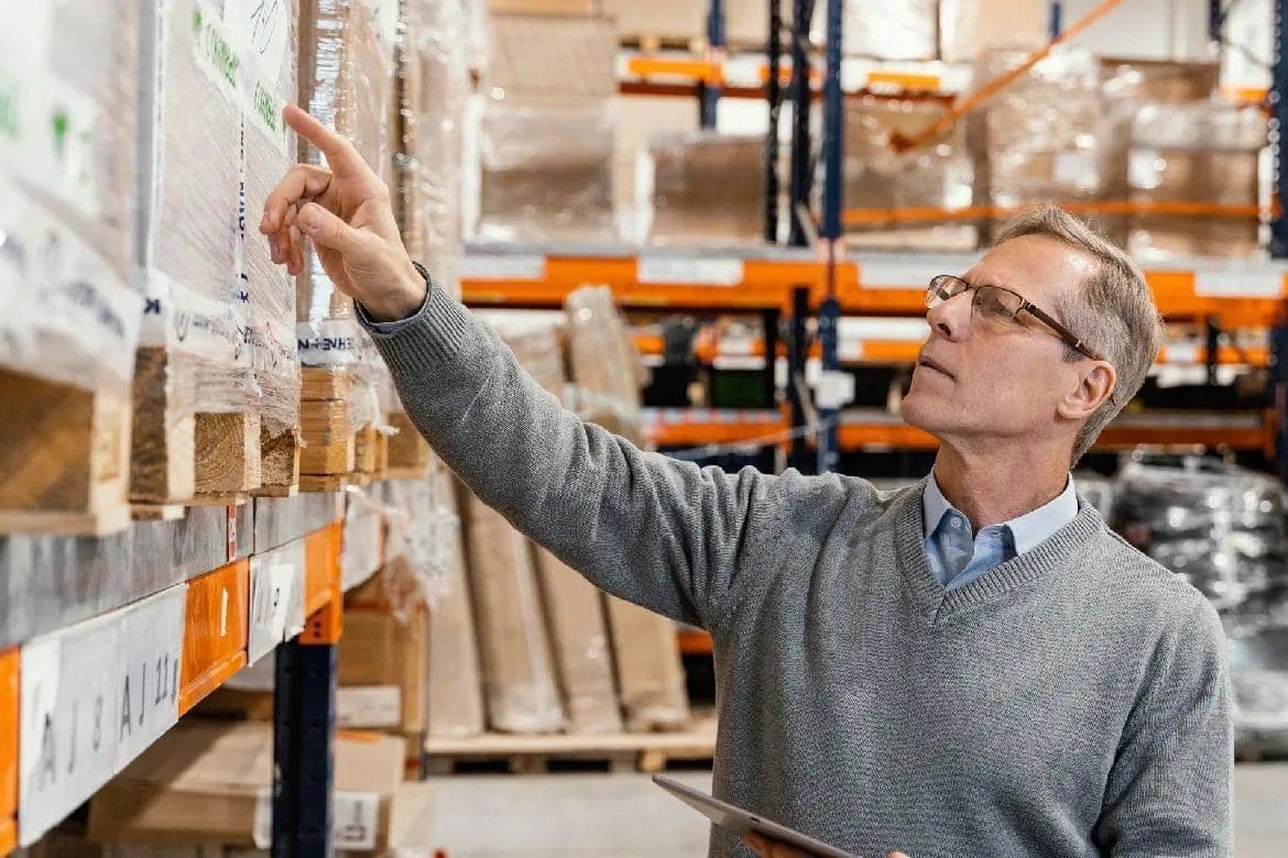 Inspector checking cartons on warehouse racking