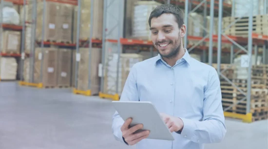 QA professional reviewing compliance on a tablet in a warehouse